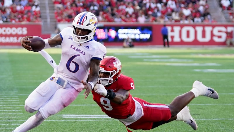 Kansas quarterback Jalon Daniels (6) escapes a tackle by Houston defensive lineman Nelson...