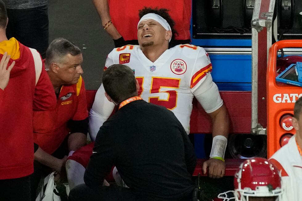 Kansas City Chiefs quarterback Patrick Mahomes (15) grimaces on the bench after an injury...