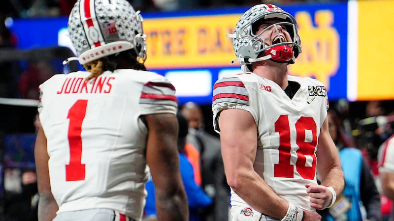 Ohio State quarterback Will Howard celebrates after a touchdown by running back Quinshon...