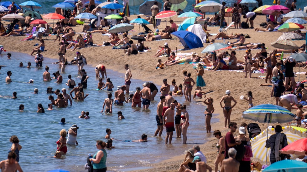 FILE - Bathers cool off in the water while others sunbathe on a Barcelona beach, Spain,...