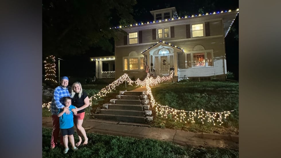 The Judy family outside their home while it's decorated for the holidays.