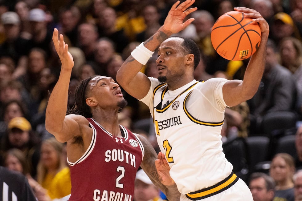 Missouri's Tamar Bates, right, es the ball around South Carolina's Zachary Davis, left,...