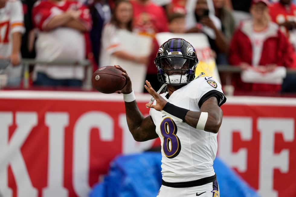 Baltimore Ravens quarterback Lamar Jackson warms up before the start of an NFL football game...