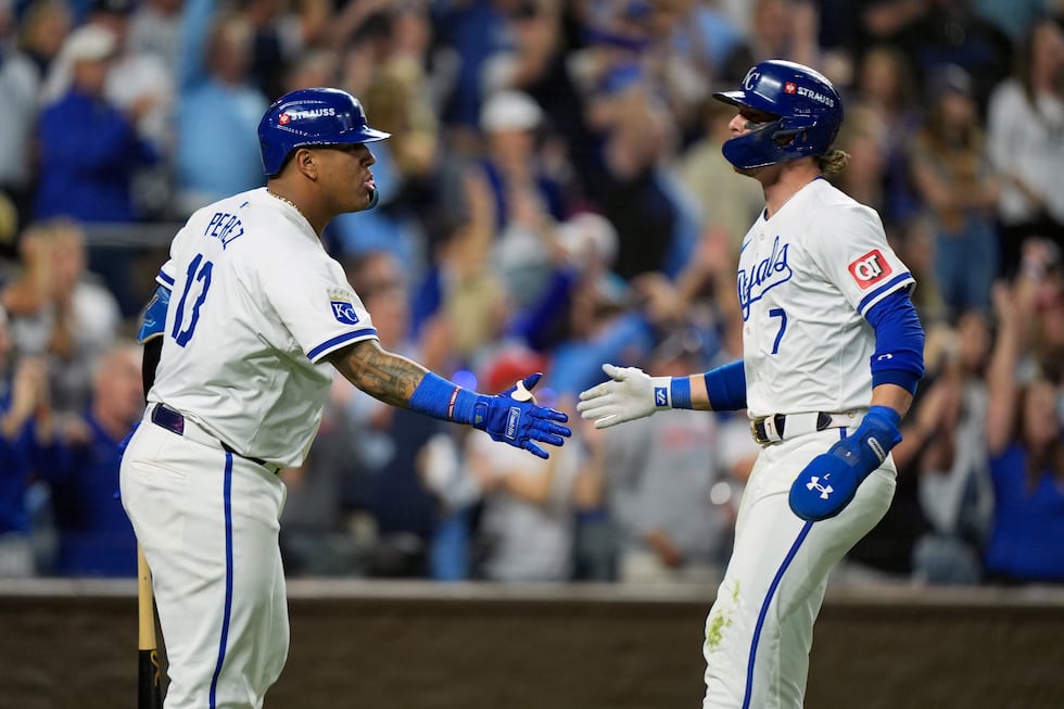 Kansas City Royals' Bobby Witt Jr. (7) is congratulated by teammate Salvador Perez (13) after...