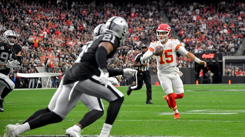 Kansas City Chiefs quarterback Patrick Mahomes (15) scrambles before ing to teammate...