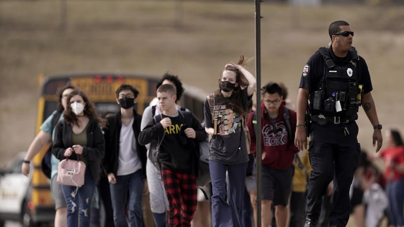 FILE - Students from Olathe East High School are lead to a staging area to reunite with their...