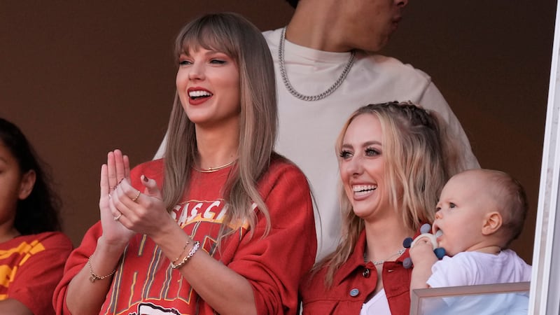 Taylor Swift cheers alongside Brittany Mahomes, right, before the start of an NFL football...