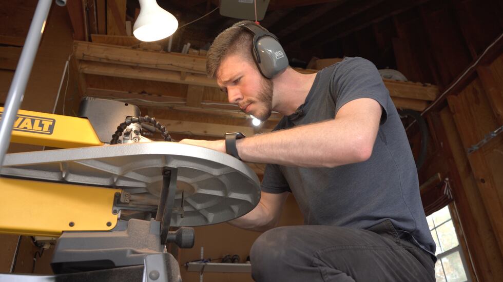 David Pentimone carves woodwork in his makeshift workshop inside his garage.