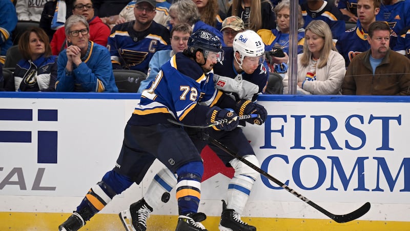 St. Louis Blues' Justin Faulk (72) and Winnipeg Jets' Jaret Anderson-Dolan, right, battle for...