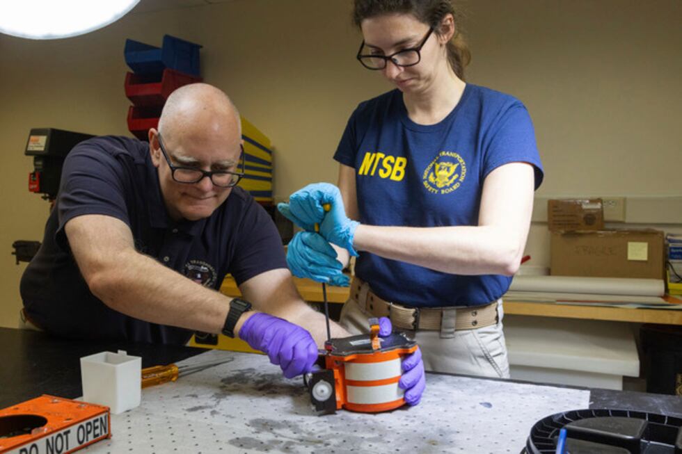 National Transportation Safety Board (NTSB) investigators examine cockpit voice recorder and...