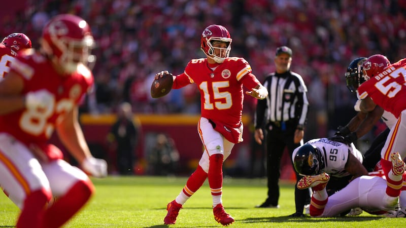 Kansas City Chiefs quarterback Patrick Mahomes runs as he throws as touchdown to wide...
