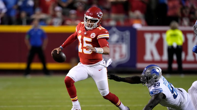 Kansas City Chiefs quarterback Patrick Mahomes (15) scrambles past Detroit Lions defensive end...