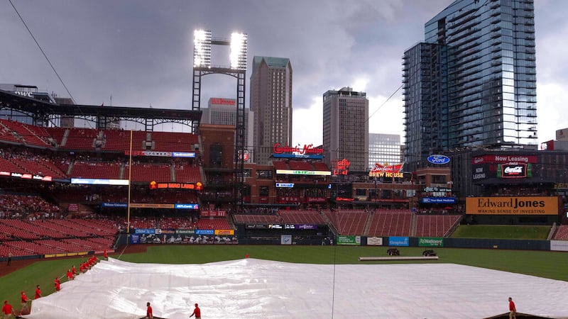 Busch Stadium is viewed as the field crew puts on the tarp during a rain delay in a baseball...