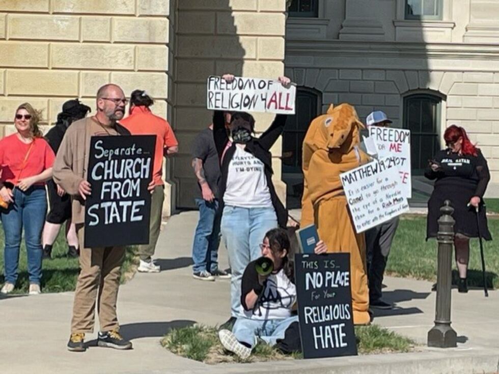 A large crowd with opposing views had gathered Friday morning outside the Kansas Statehouse in...