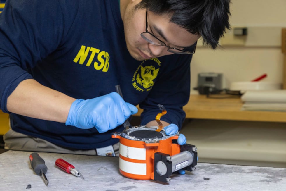 National Transportation Safety Board (NTSB) investigators examine cockpit voice recorder and...
