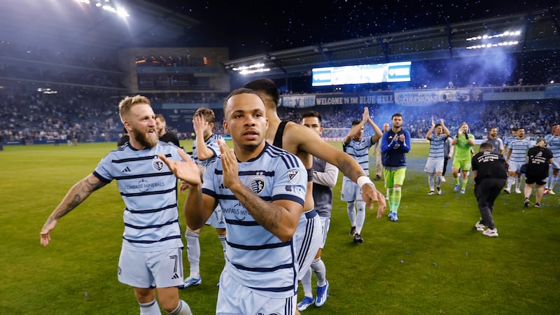 Sporting Kansas City's Johnny Russell (7) and Logan Ndenbe (18) celebrate with teammates at...
