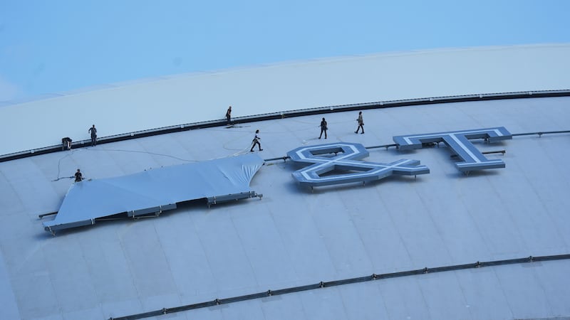 Workers cover signage on the exterior of AT&T Stadium, which will be named Dallas Stadium...