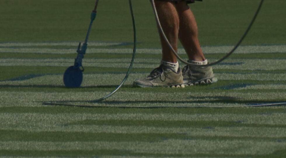 Crews use an easily removable chalk-like paint for KU football games at Children's Mercy Park,...