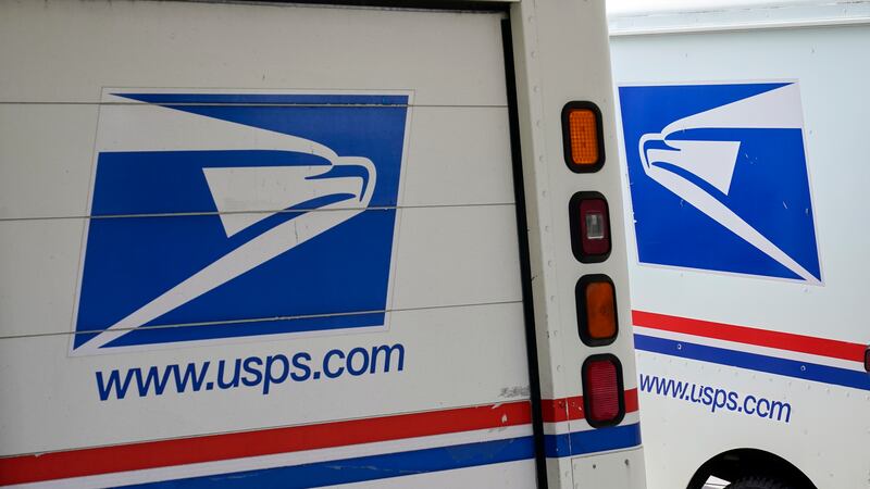 FILE - U.S. Postal Service delivery vehicles are parked outside a post office in Boys Town,...