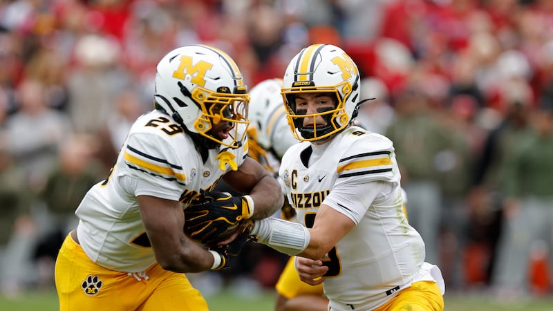 Missouri quarterback Beau Pribula (9) hands off the ball to Missouri running back Ahmad Hardy...