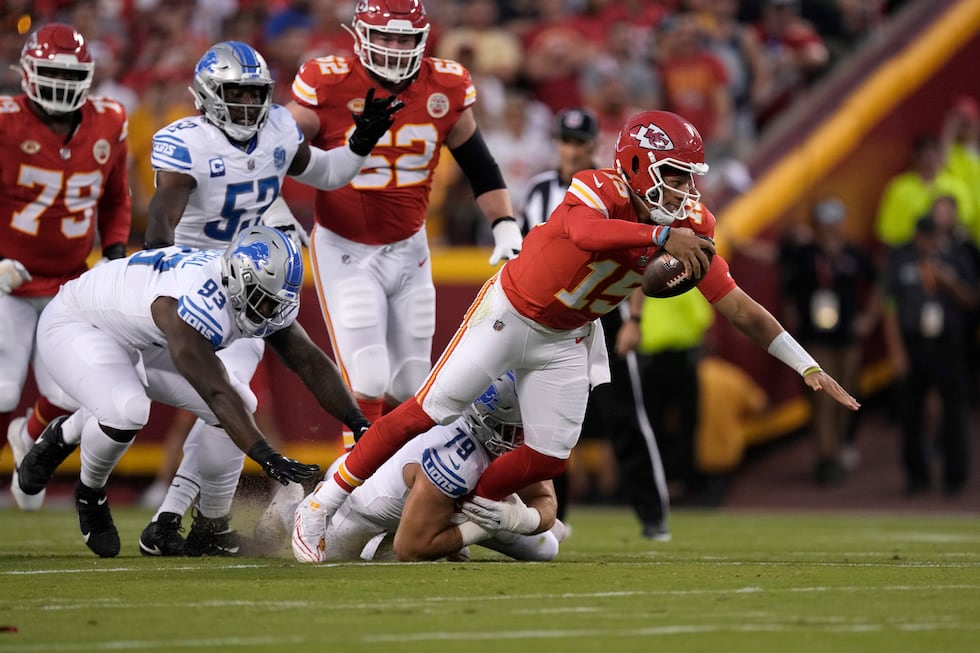 Kansas City Chiefs quarterback Patrick Mahomes, right, struggles for yardage as Detroit Lions...