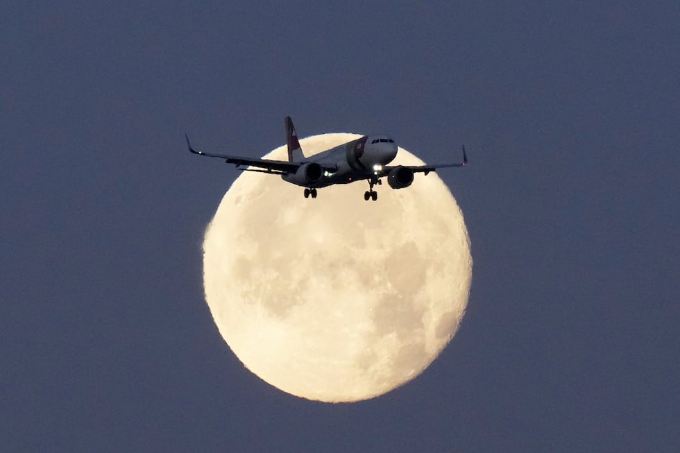 FILE - A TAP Air Portugal Airbus A320 is silhouetted against the setting moon while...