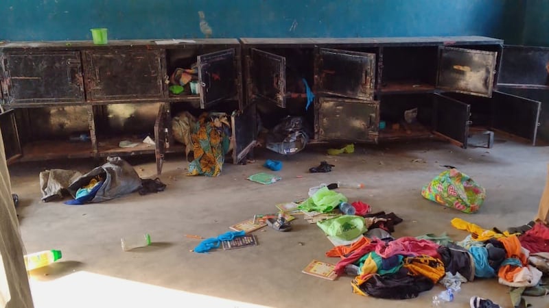 In this photo released by Christian Association of Nigeria, a man walk past belongings at the...