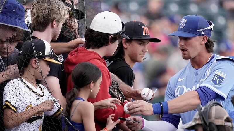 Kansas City Royals' Bobby Witt Jr. signs autographs before a spring training baseball game...