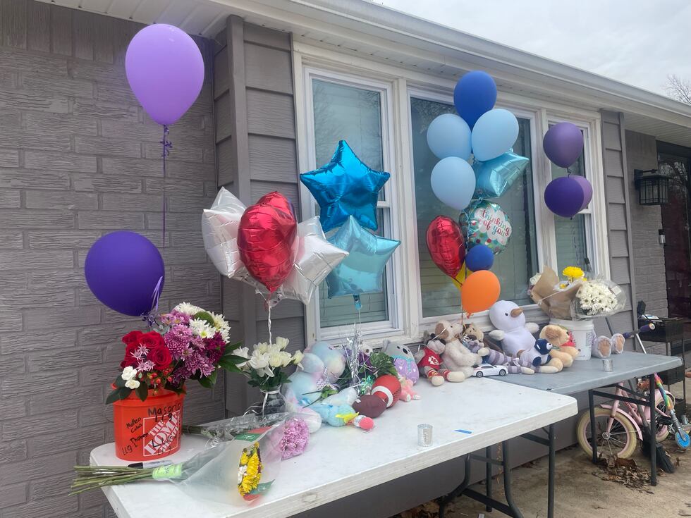Balloons, teddy bears and flowers line the outside of the home where 12-year-old Giuliani...