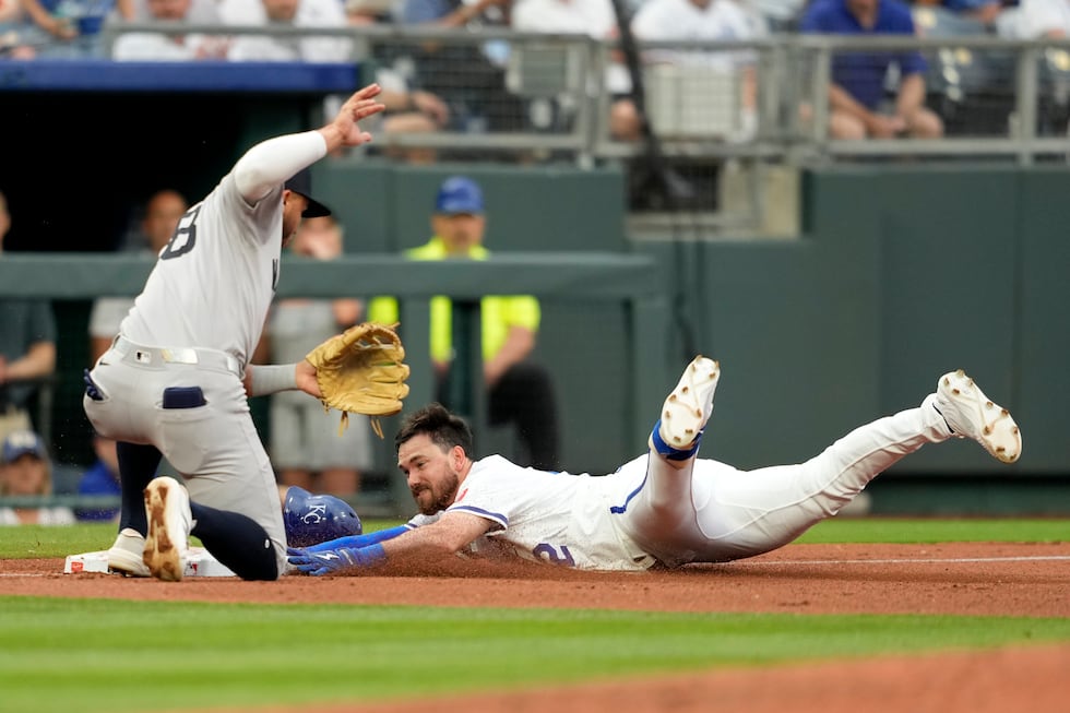 Kansas City Royals' Nick Loftin, right, slides into third with a triple past New York Yankees...