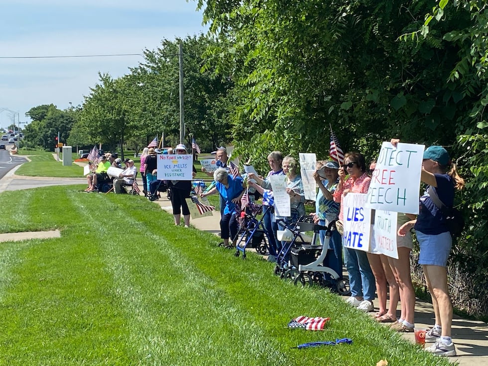 People protest outside a retirement home at 130th and Metcalf in Overland Park.