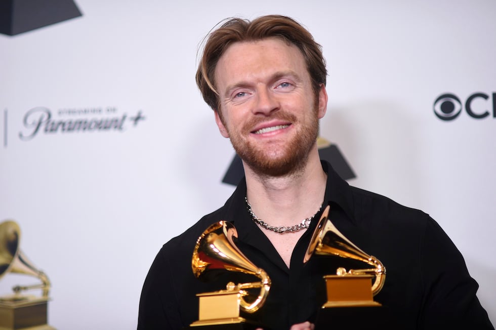 Finneas poses in the press room with the awards for best song written for visual media and...