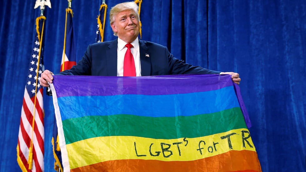 Donald Trump unfurls an LGBTQ flag during a campaign rally in Colorado.