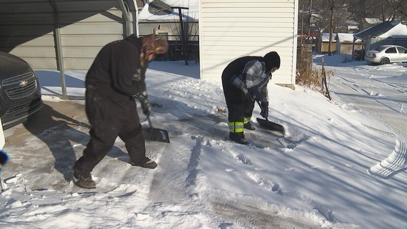 Summer Gifford and Corey Sutton shovel a neighbor's driveway on Feb. 20, 2025.