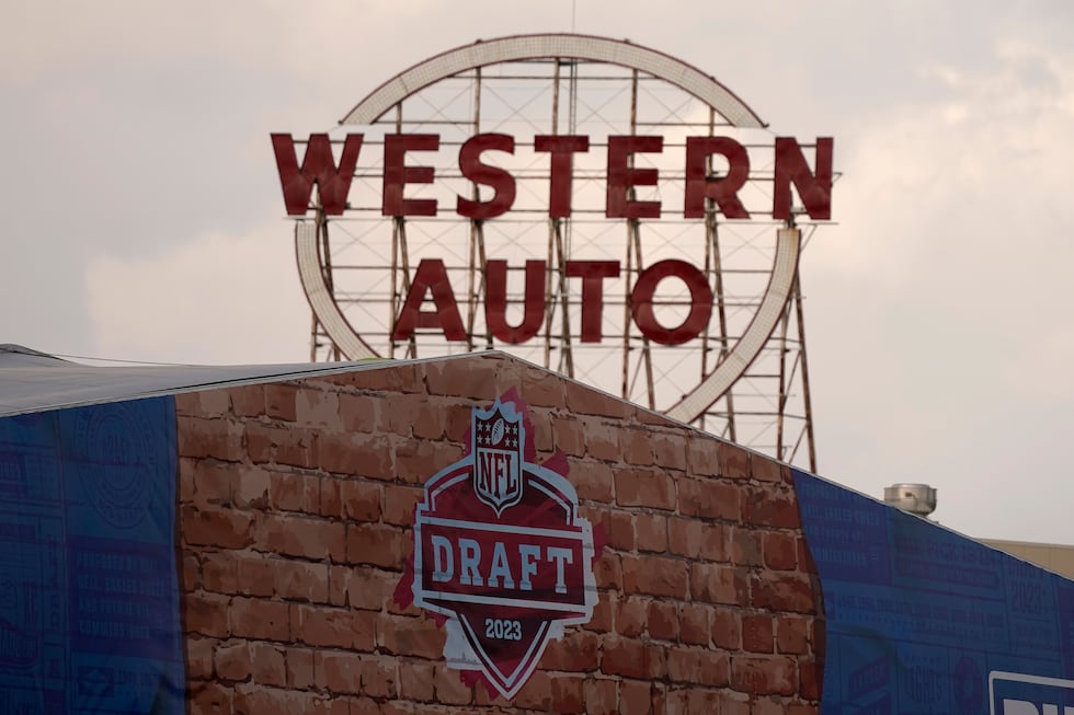 A historic sign on a nearby building rises above the Draft Stage as work for the NFL Draft...