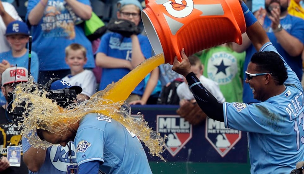 Kansas City Royals' Salvador Perez, right, douses teammate Alex Gordon, left, following a...