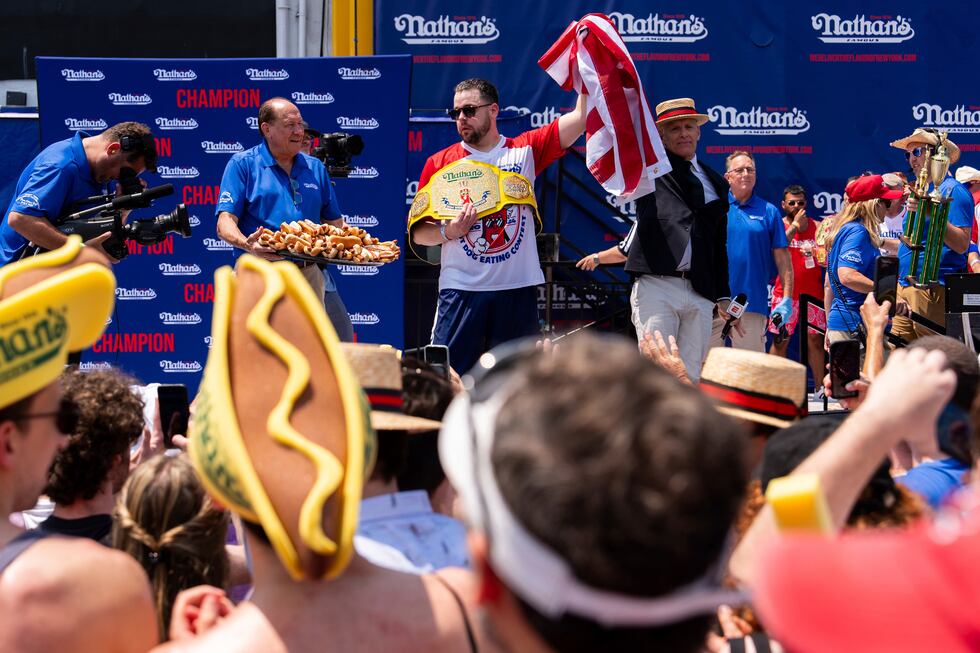 Patrick Bertoletti, center, reacts after winning the men's division in Nathan's Famous Fourth...
