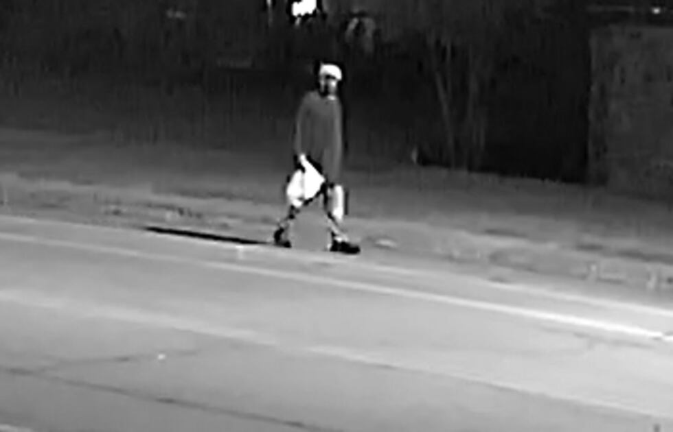 A man can be seen walking north on 10th St. towards Reynolds, carrying a white plastic bag.