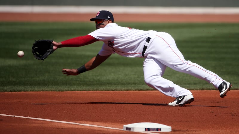 Boston Red Sox third baseman Rafael Devers dives but cannot make a play on a double by Kansas...