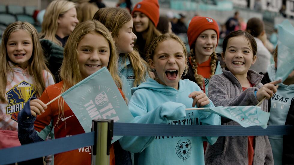 Young fans of the Kansas City Current cheer on the team during a playoff game at KC Stadium.