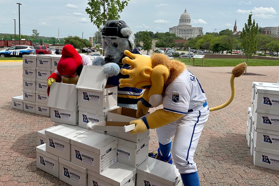 Mascots for the Kansas City Royals, St. Louis Blues and St. Louis Cardinals haul boxes of...