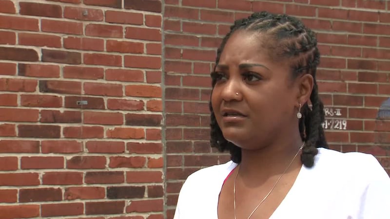 A woman says she fell into an open manhole while walking on the sidewalk toward a nearby bar....